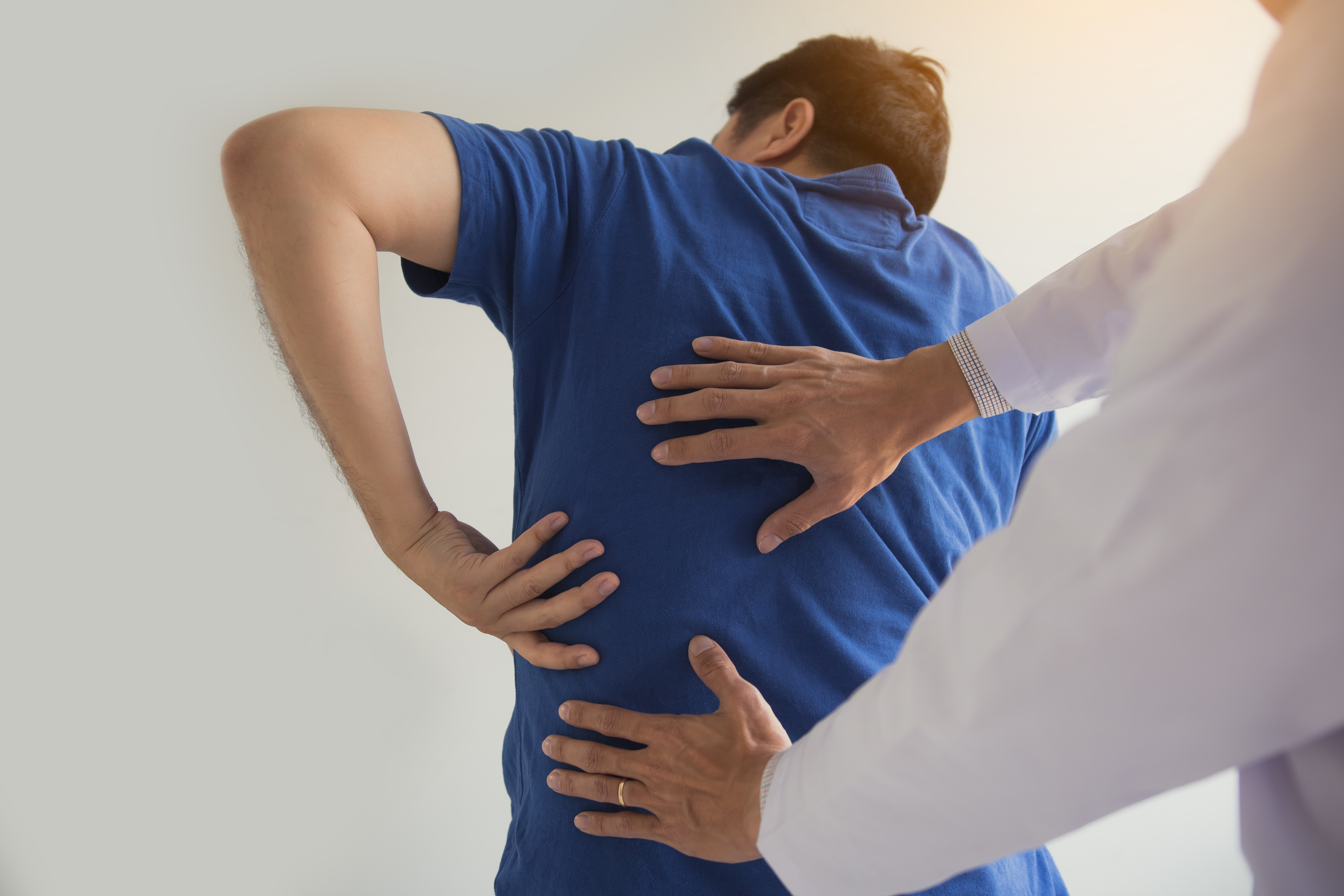 Man being helped with back pain.